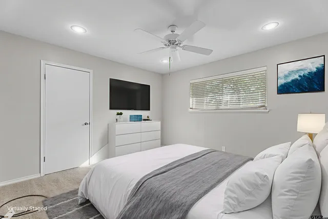 an empty room with a ceiling fan and window