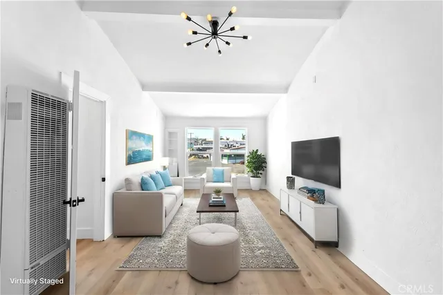 a living room with furniture a chandelier and a flat screen tv