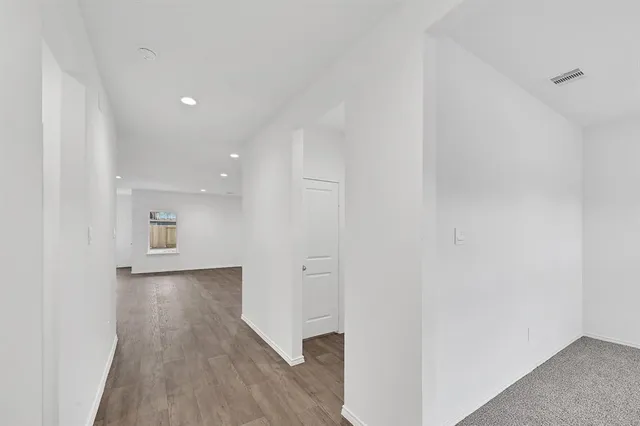 a view of a hallway with wooden floor