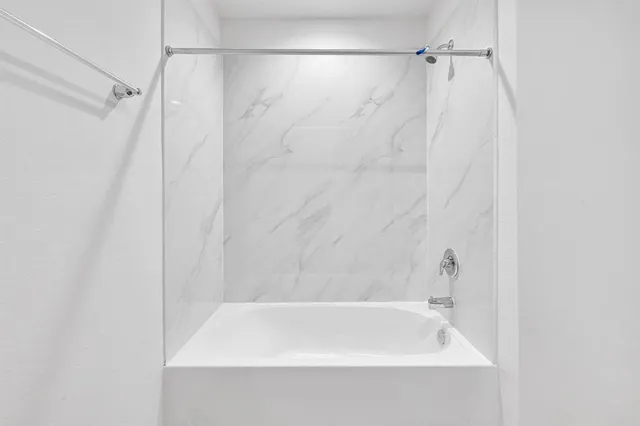 a bathroom with a shower and a bath tub