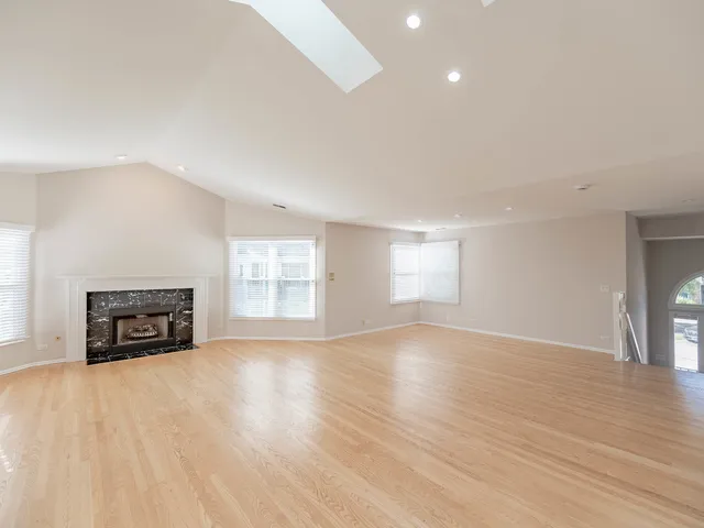 an empty room with windows fire place and a fireplace