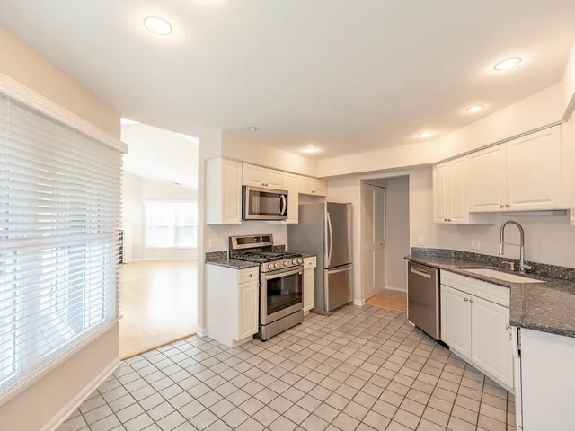a kitchen with stainless steel appliances granite countertop a stove a sink and a refrigerator