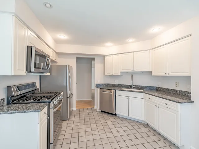 a kitchen with granite countertop a stove sink and cabinets
