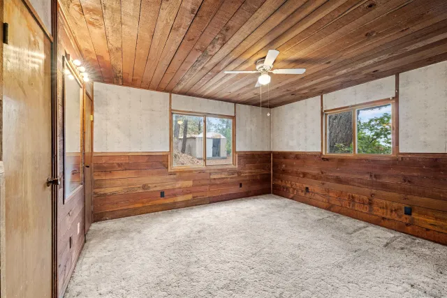 a bedroom with a bed and a dresser next to a window