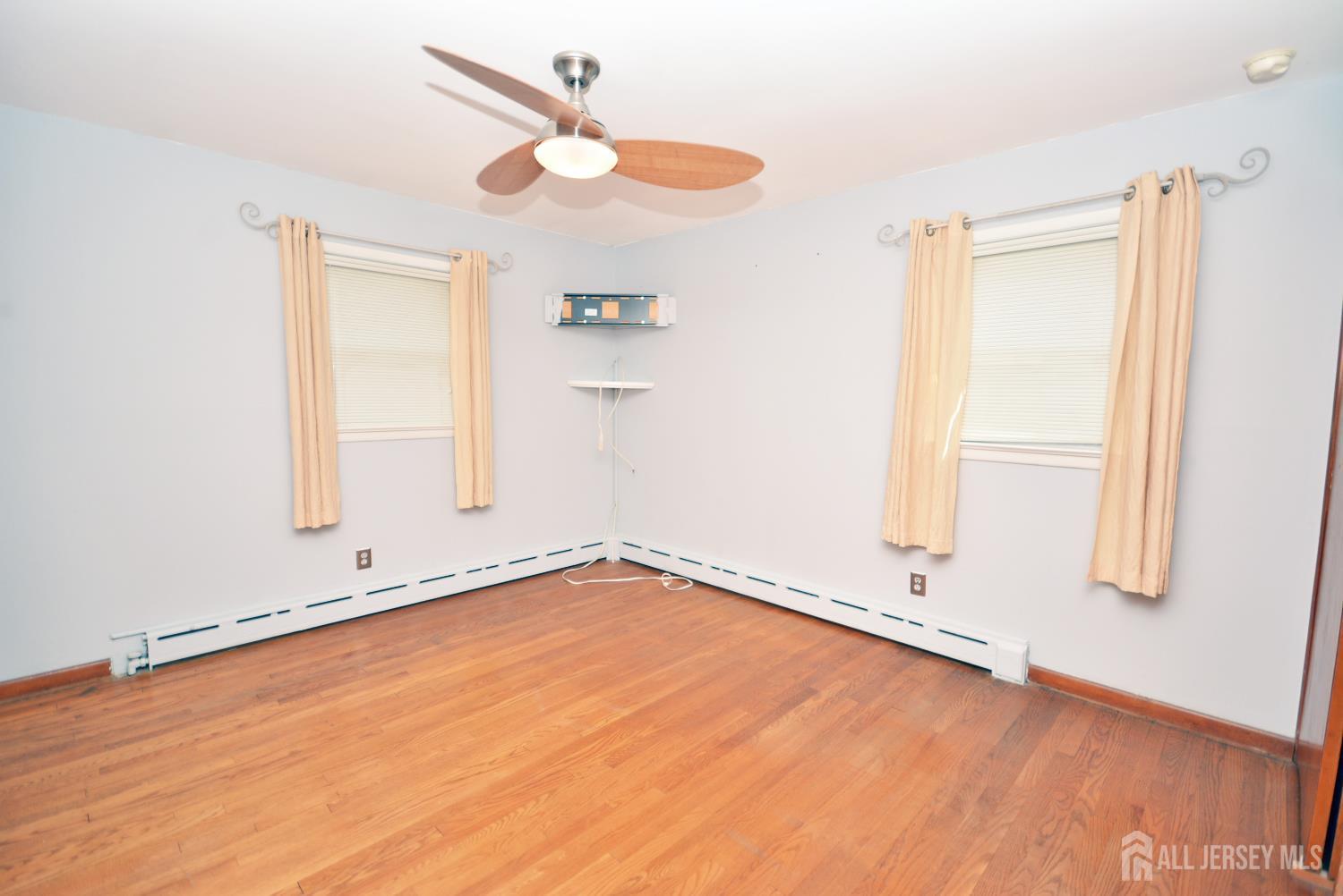 9 Emma Place Middlesex, NJ 08846 - Photo 12 of 32 an empty room with wooden floor fan and windows