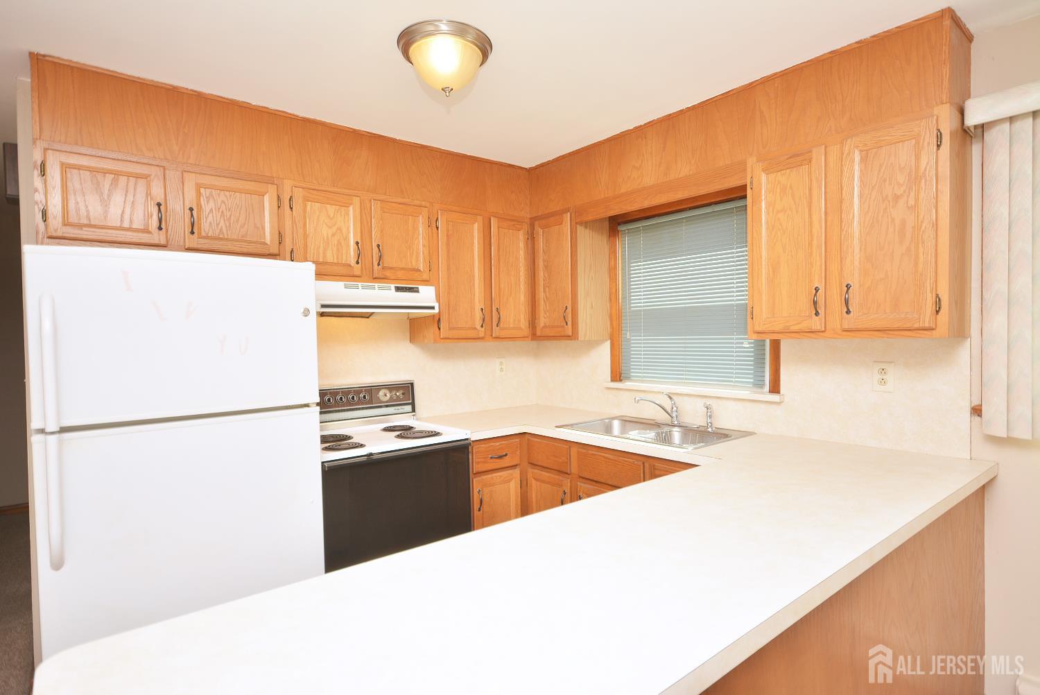 9 Emma Place Middlesex, NJ 08846 - Photo 4 of 32 a kitchen with a refrigerator a sink and cabinets