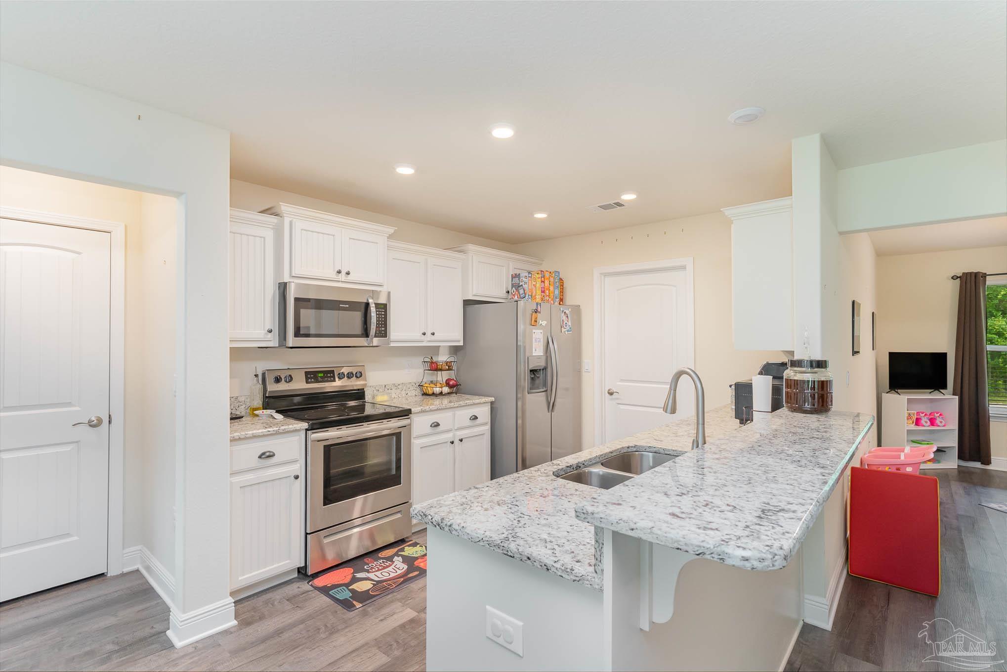 3315 Doyle Hawkins Road Navarre, FL 32566 - Photo 11 of 33 a kitchen with stainless steel appliances granite countertop a sink dishwasher stove top oven and refrigerator
