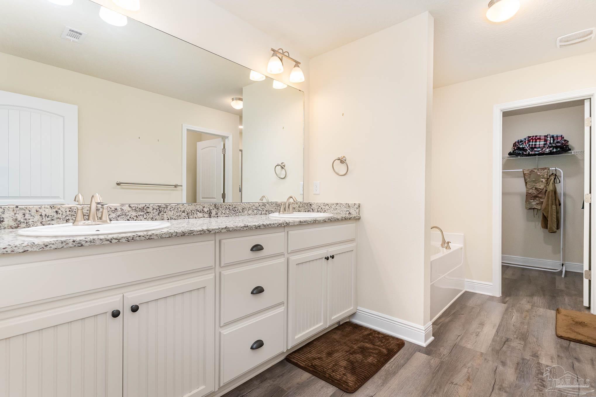 3315 Doyle Hawkins Road Navarre, FL 32566 - Photo 13 of 33 a bathroom with a granite countertop sink and a mirror