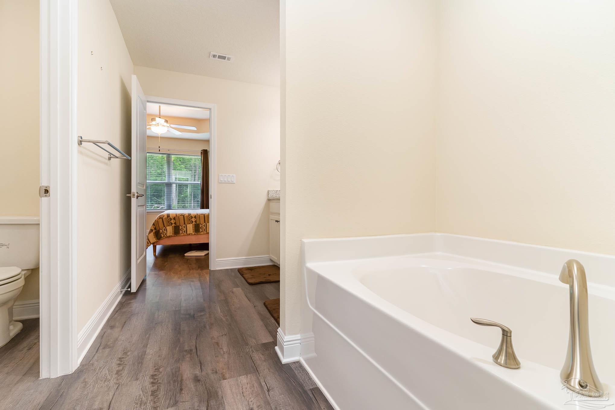 3315 Doyle Hawkins Road Navarre, FL 32566 - Photo 15 of 33 a bathroom with a tub a sink and a window