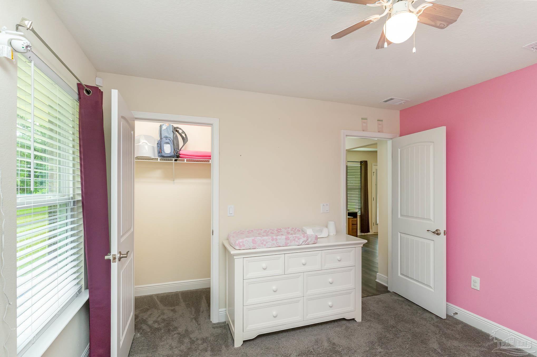 3315 Doyle Hawkins Road Navarre, FL 32566 - Photo 17 of 33 a view of room with closet and a ceiling fan