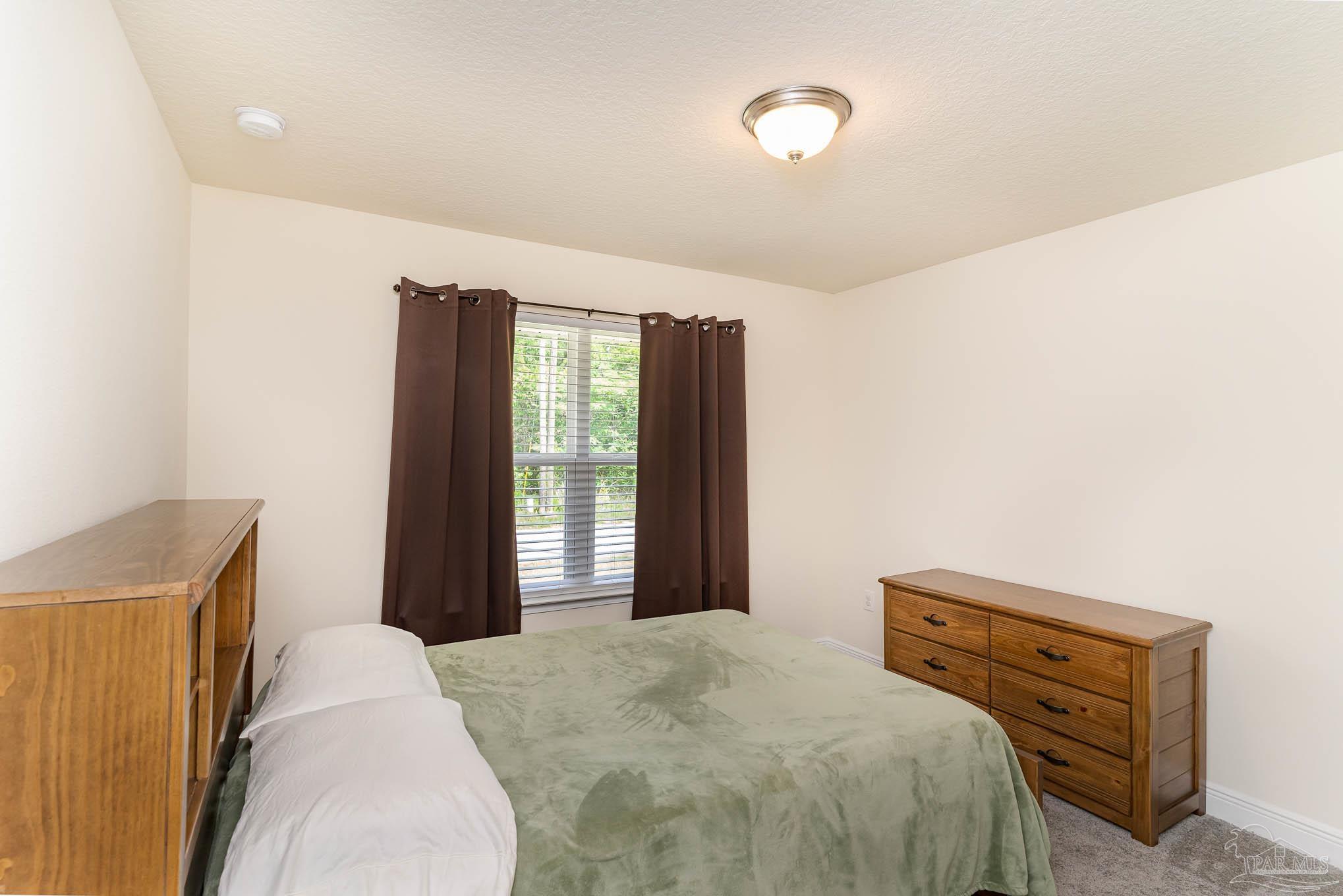 3315 Doyle Hawkins Road Navarre, FL 32566 - Photo 19 of 33 a bedroom with a bed and a large window