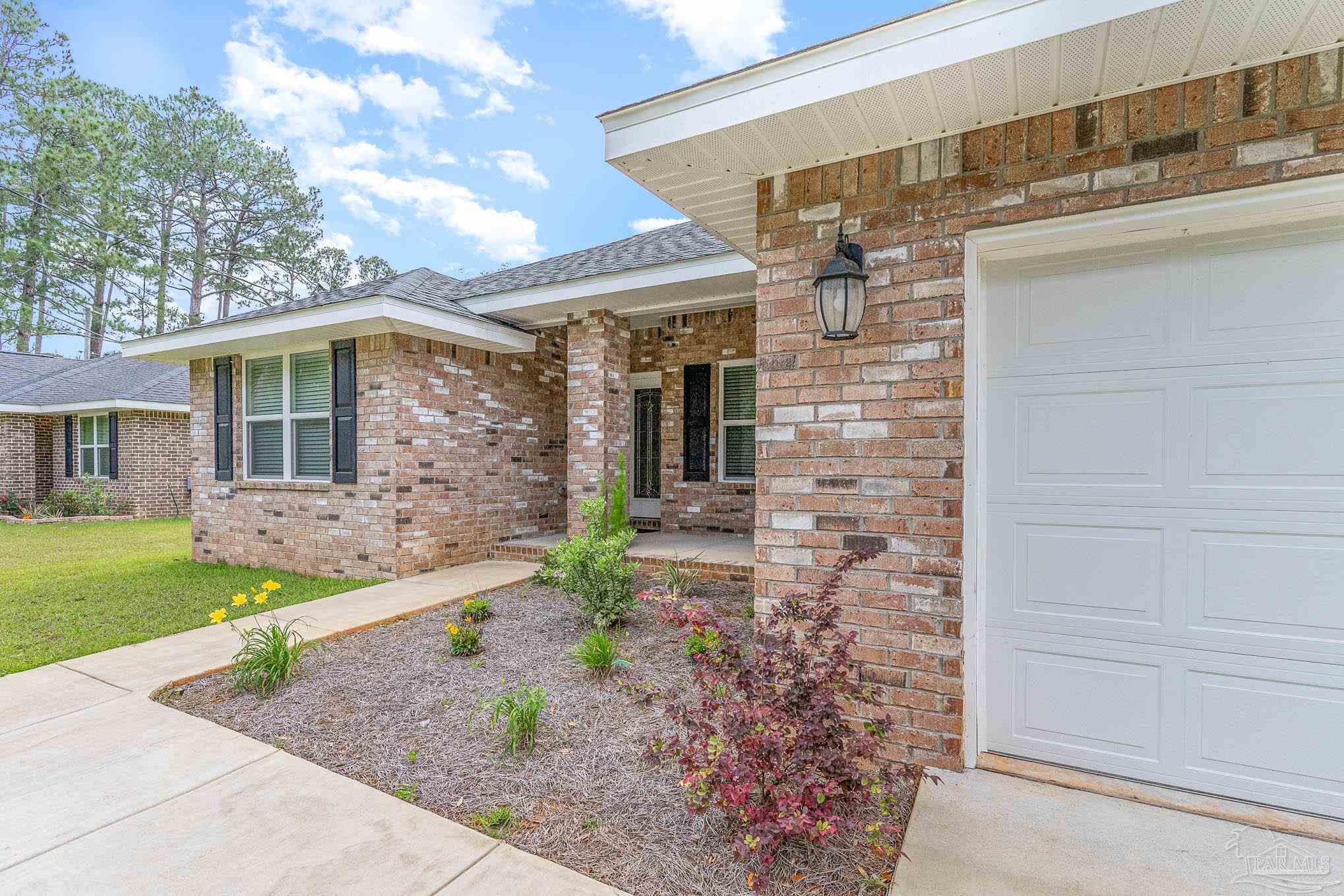 3315 Doyle Hawkins Road Navarre, FL 32566 - Photo 2 of 33 a front view of a house with garden