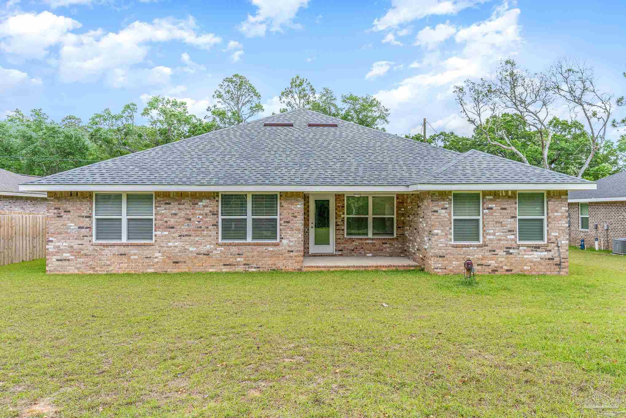 3315 Doyle Hawkins Road Navarre, FL 32566 - Photo 30 of 33 a front view of a house with a garden and patio