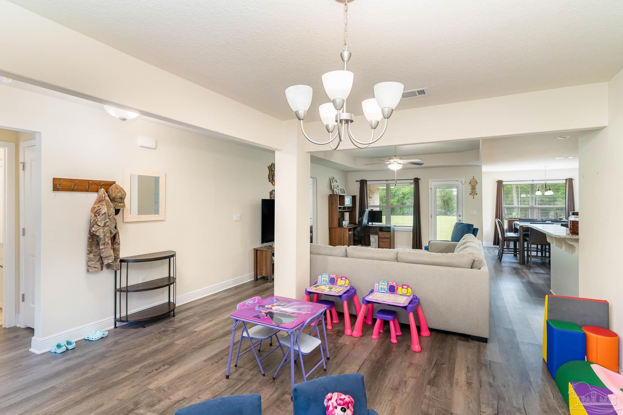 3315 Doyle Hawkins Road Navarre, FL 32566 - Photo 5 of 33 a view of a livingroom with furniture wooden floor and chandelier