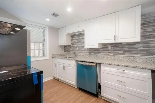 a kitchen with granite countertop cabinets stainless steel appliances and a sink
