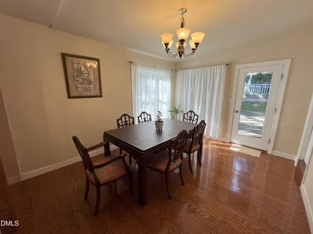 a view of a dining room with furniture wooden floor and chandelier