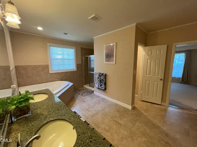 a bathroom with a granite countertop sink a mirror and a shower