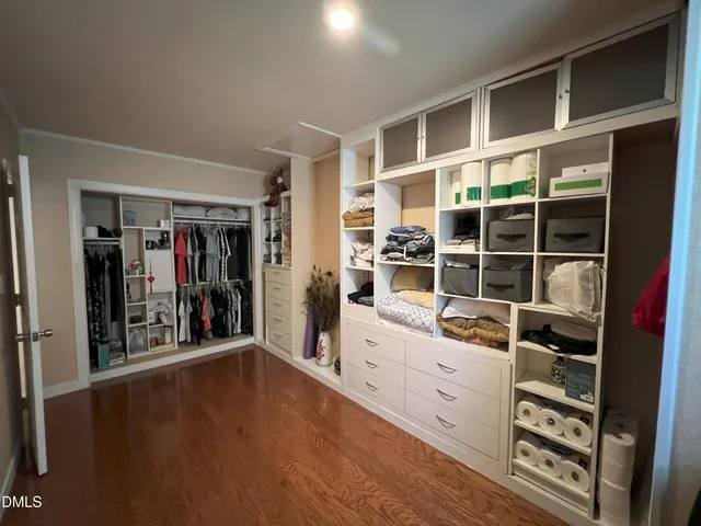 a view of a big room with wooden floor and windows