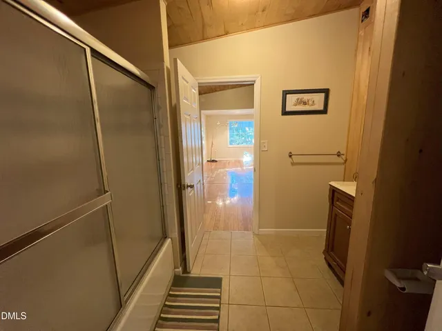 a view of a bedroom with a bed and wooden floor
