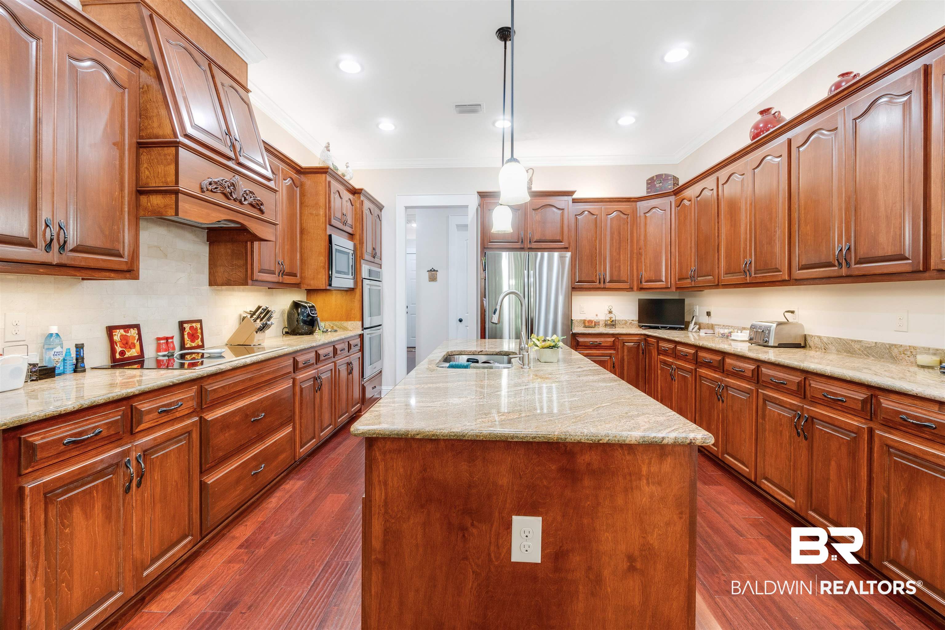 11281 Redfern Road Daphne, AL 36526 - Photo 17 of 80 Kitchen with stainless steel appliances, sink, an island with sink, dark wood-type flooring, and pendant lighting