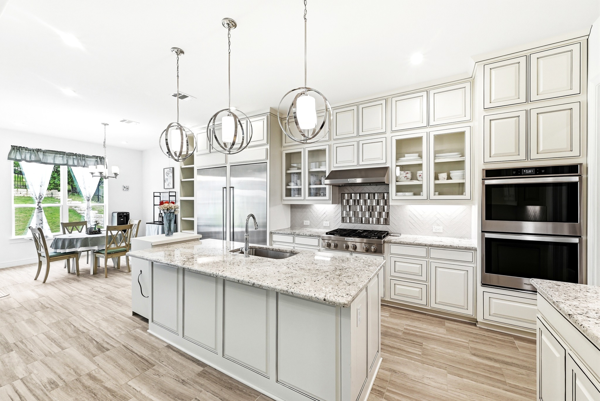 4601 Apollonia Way Leander, TX 78641 - Photo 4 of 40 a kitchen with granite countertop a stove a oven a dining table and chairs with wooden floor