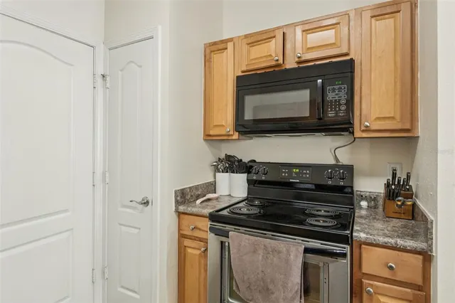 a kitchen with stainless steel appliances granite countertop white cabinets and a stove top oven