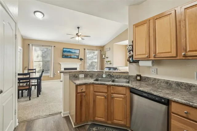 a kitchen with stainless steel appliances granite countertop a stove a sink dishwasher and cabinets with wooden floor