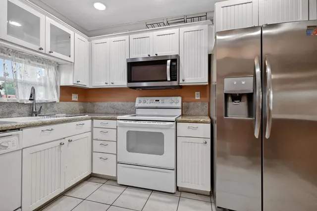 a kitchen with white cabinets stainless steel appliances and a counter space