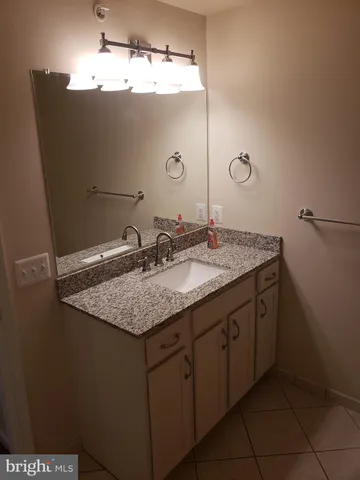a bathroom with a granite countertop sink and a mirror
