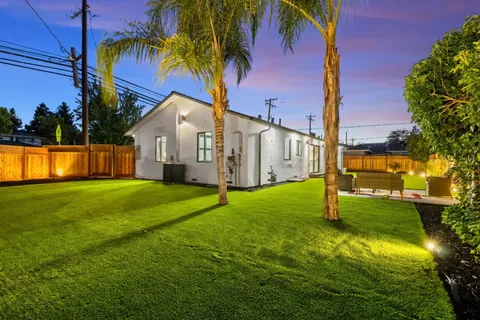 a backyard of a house with lots of green space and lake view