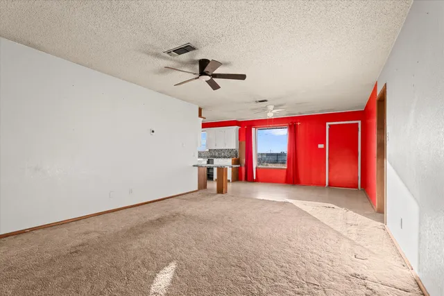 a view of empty room with window and ceiling fan