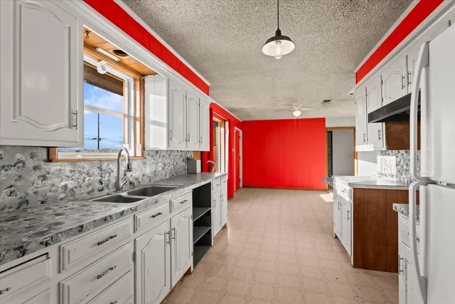 a kitchen that has a lot of cabinets in it with granite countertop stainless steel appliances