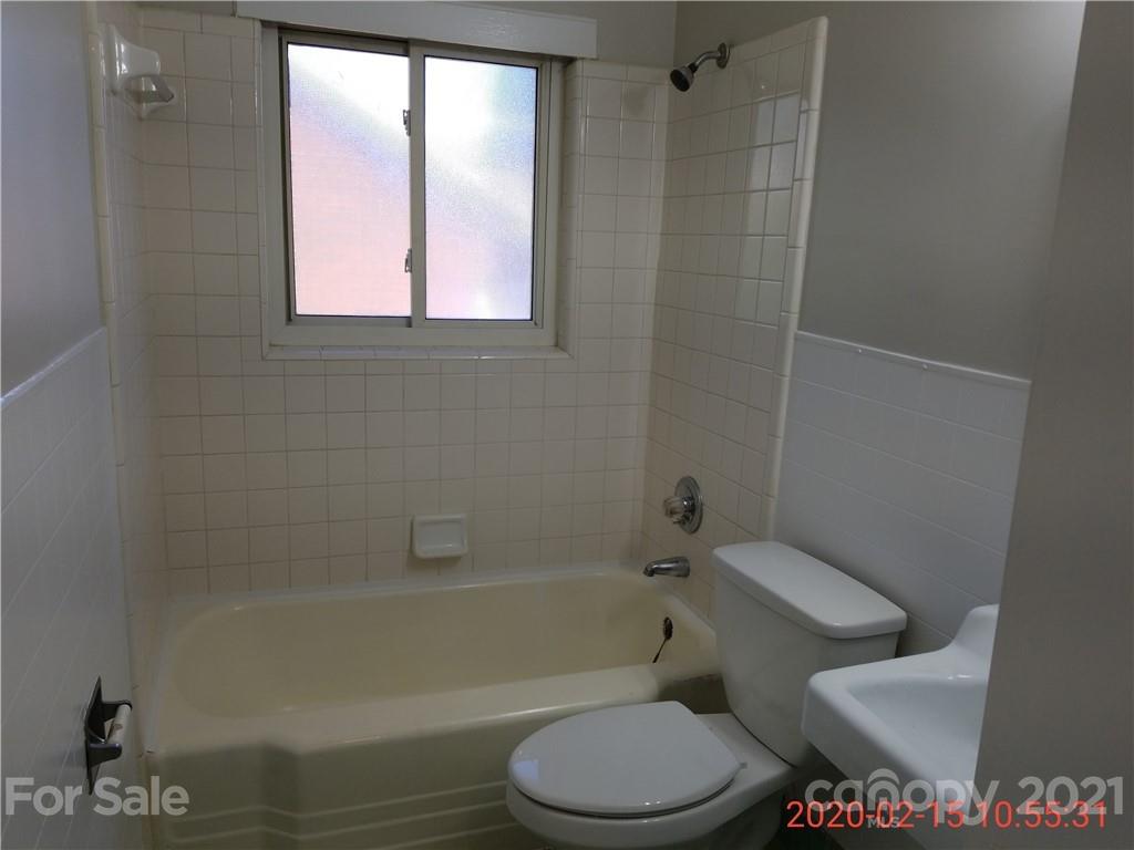 2128 North Sharon Amity Road Charlotte, NC 28212 - Photo 8 of 15 a white toilet and tub next to a window