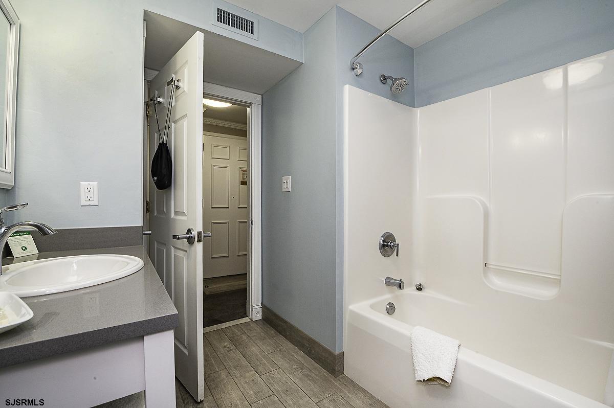 719 East 11th Street, Unit 915 Ocean City, NJ 08226 - Photo 17 of 27 a bathroom with a tub a sink and a large mirror
