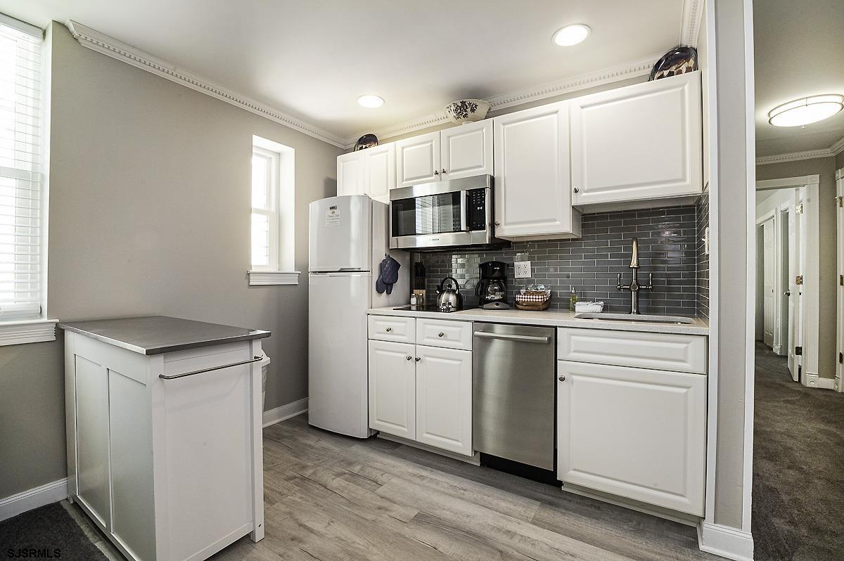 719 East 11th Street, Unit 915 Ocean City, NJ 08226 - Photo 2 of 27 a kitchen with white cabinets stainless steel appliances and sink