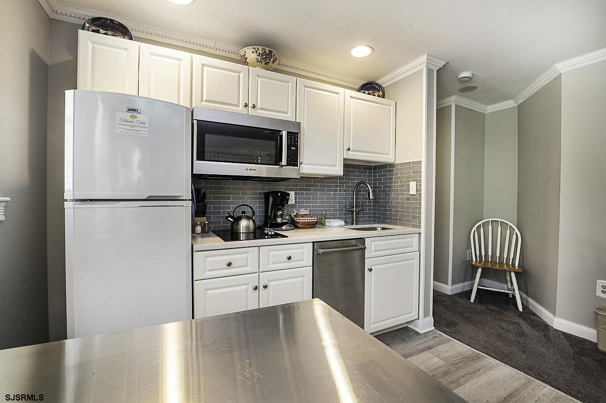 719 East 11th Street, Unit 915 Ocean City, NJ 08226 - Photo 3 of 27 a kitchen with stainless steel appliances a refrigerator sink and microwave