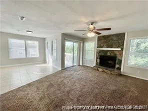 a view of an empty room with a fireplace and a window