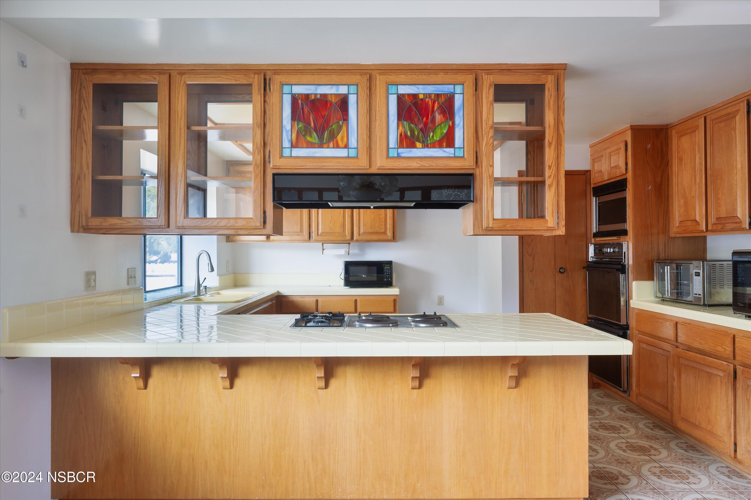 970 Onstott Road Lompoc, CA 93436 - Photo 14 of 38 a kitchen with kitchen island granite countertop a stove top oven a sink a counter space and cabinets
