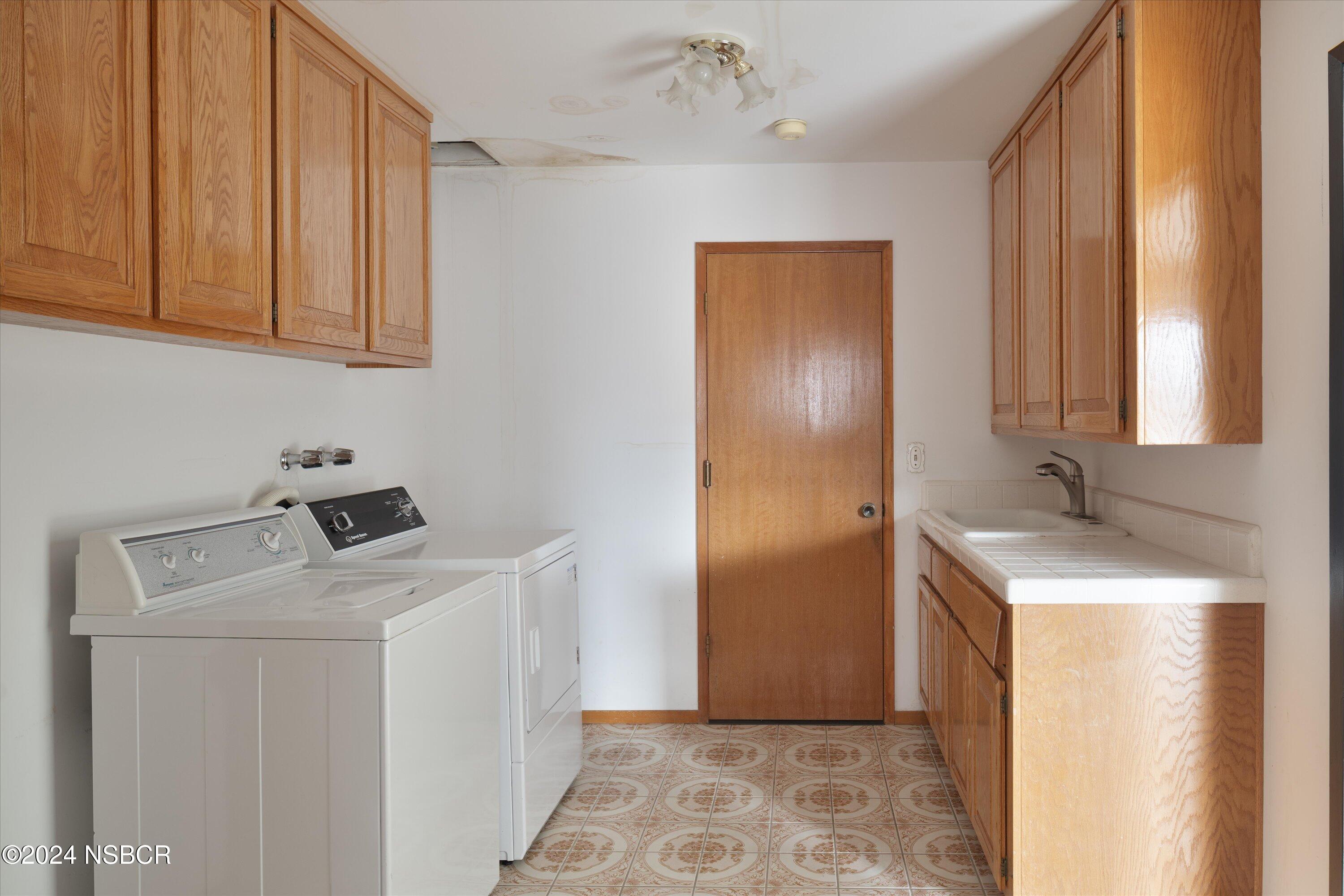 970 Onstott Road Lompoc, CA 93436 - Photo 29 of 38 a utility room with cabinets washer and dryer