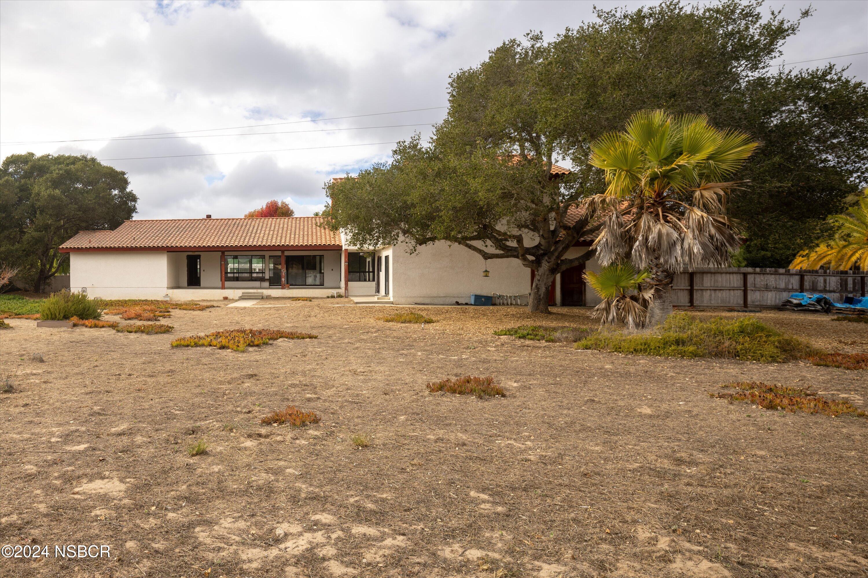 970 Onstott Road Lompoc, CA 93436 - Photo 32 of 38 a view of a white house with a big yard and large trees