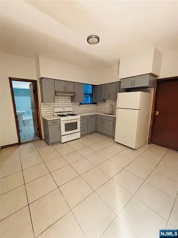 a kitchen with a refrigerator and a stove top oven