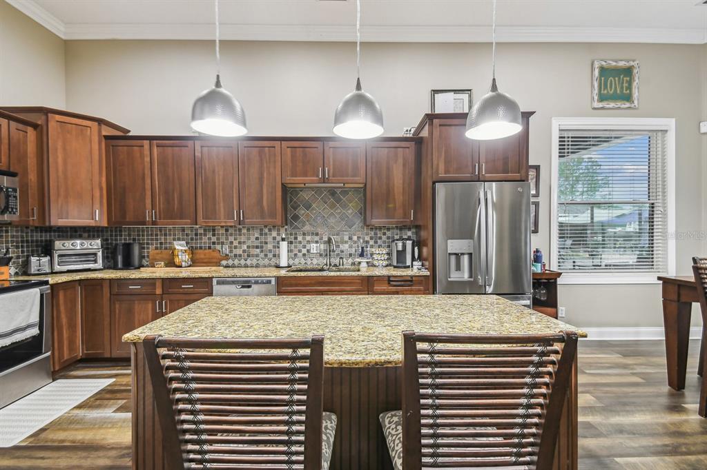 19315 Lake Pickett Road Orlando, FL 32820 - Photo 38 of 90 a kitchen with stainless steel appliances granite countertop a sink a stove and a refrigerator