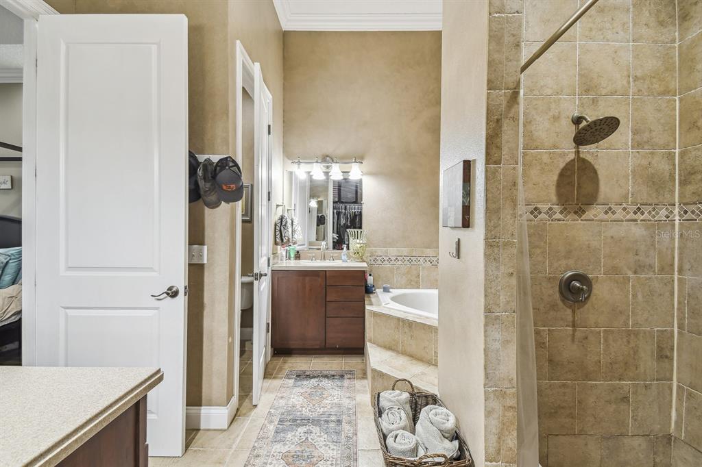 19315 Lake Pickett Road Orlando, FL 32820 - Photo 50 of 90 a bathroom with a glass door shower a sink and a mirror