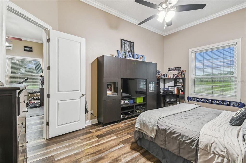 19315 Lake Pickett Road Orlando, FL 32820 - Photo 55 of 90 a bedroom with a bed and a large mirror with a flat tv screen