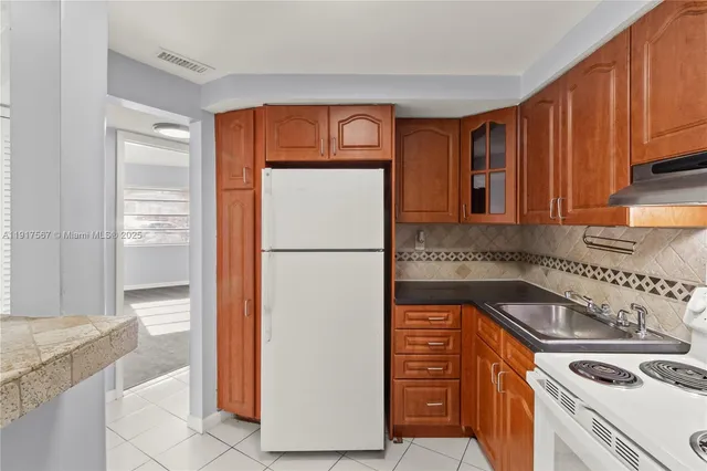 a kitchen with a refrigerator sink and cabinets