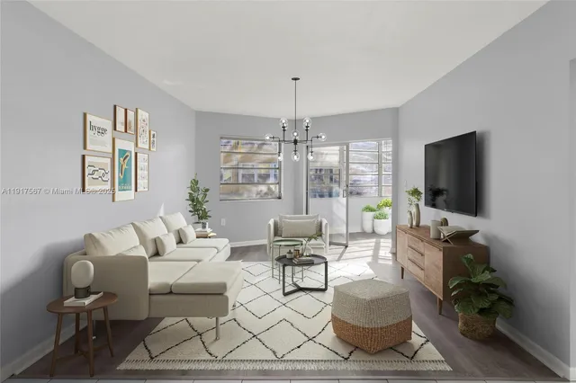 a living room with furniture a flat screen tv and a chandelier