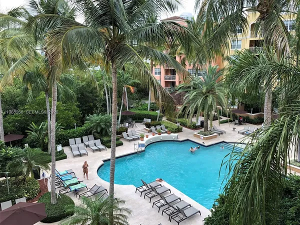 a view of swimming pool with chairs and plants