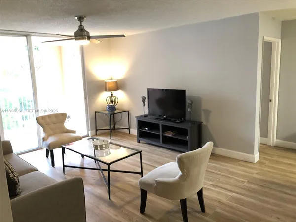 a living room with furniture a lamp and a flat screen tv