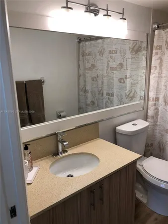 a white toilet and tub sitting next to a bathroom sink