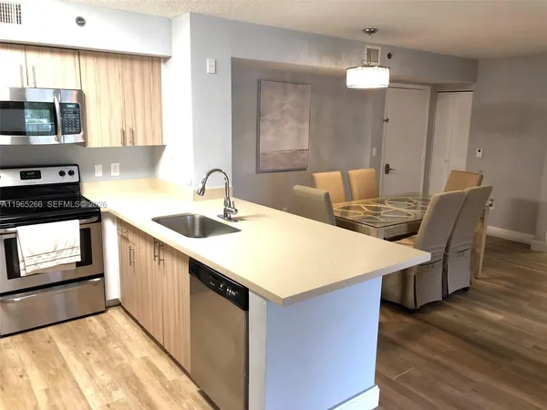 a kitchen with a table chairs sink and cabinets